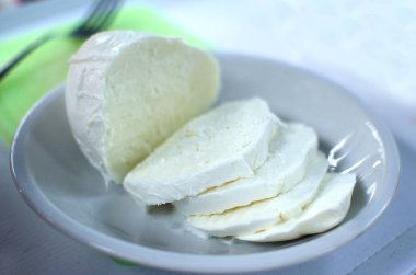 Beyaz plaka üzerinde mozzarella kesme
