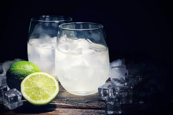 Drink with ice in a glass beaker with a lime slice. Moonlight