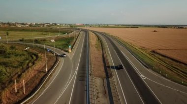 Ulaştırma Kavşağı görüntülerini hava dron yaz, çapraz yol kavşağı gün görünümü yukarıdan yeşil ağaç daire yol ile trafik, yakın bir buğday alandır. Yukarıdan aşağıya trafik sıkışıklığı görünümünü.