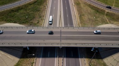 Ulaşım kavşağının yaz havası fotoğrafı, kavşak kavşağı kavşağının kavşak noktası yukarıdan daire şeklinde görünüyor. Trafik sıkışıklığının yukarıdan aşağı görüntüsü.