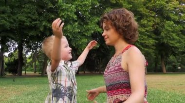 Neşeli çocuk hugs onun annesi, Anne gülümser, mutlu