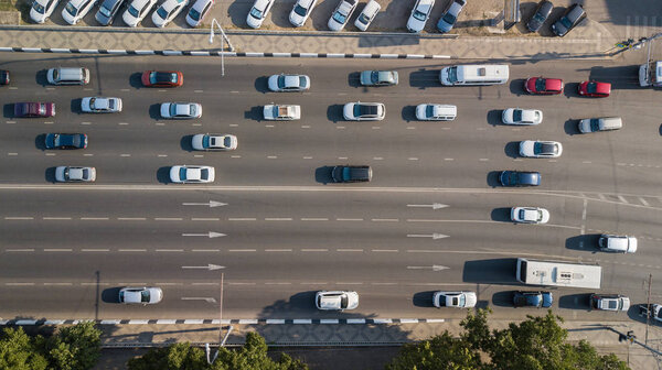 Воздушный беспилотный полет сверху Вид на оживлённое шоссе в час пик. Вид с воздуха на автомобильный перекресток, движение в часы пик с автомобилями на дороге, через мост
.
