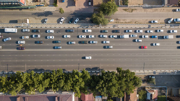 Воздушный беспилотный полет сверху Вид на оживлённое шоссе в час пик. Вид с воздуха на автомобильный перекресток, движение в часы пик с автомобилями на дороге, через мост
.
