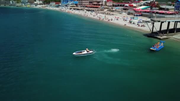 海上的一个热门景点 一艘机动船 与游客一起拉着香蕉船 俄罗斯的旅游胜地放松 黑海海边的无人驾驶飞机 — 图库视频影像