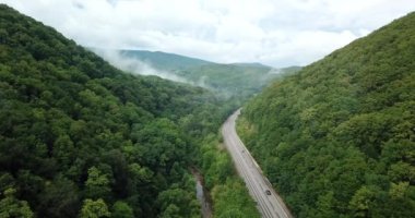4 k hava Stok görüntüleri dolambaçlı dağ pass yol Sochi, Rusya'nın Ormanı boyunca sürüş araba. İnsanlar seyahat, güzel kırsal manzara virajlı yolda yolculuk.