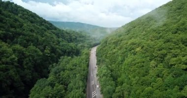 4 k hava Stok görüntüleri dolambaçlı dağ pass yol Sochi, Rusya'nın Ormanı boyunca sürüş araba. İnsanlar seyahat, güzel kırsal manzara virajlı yolda yolculuk.
