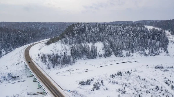 Luftaufnahme einer Landstraße, die durch die wunderschöne, schneebedeckte Landschaft führt. — Stockfoto