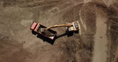 Ekskavatör havadan görünümü kamyona kum dökülen.