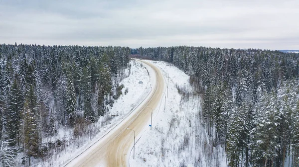 Luftaufnahme des schneebedeckten Waldes, Straße im Winter — Stockfoto