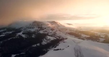 Anteni Drone uçuş üzerinde dağ silsilesi günbatımı bulutlara aracılığıyla