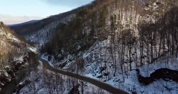 Vista aérea de un camino de montaña cubierto de nieve — Vídeos de Stock