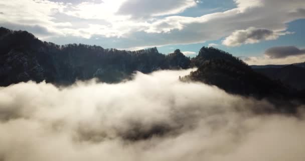 Fantastyczny lot przez mgłę pokryte górami w świetle poranka. — Wideo stockowe
