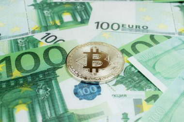 100 Euro banknotta Bitcoin gümüş sikkelerinin yakın çekimi. Kripto para birimi Btc.