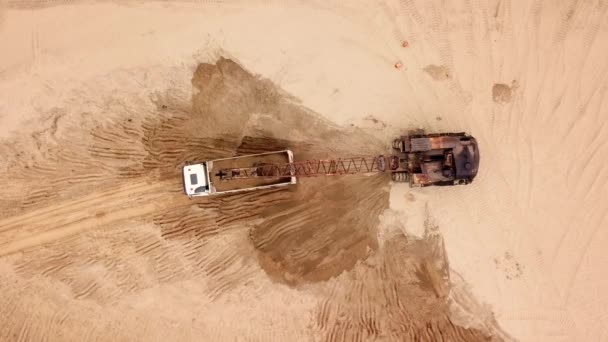 Directly above view of excavator pours sand into the truck. On the construction site. — Stock Video