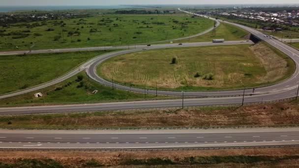 Aerial view of modern highway road intersection with traffic circle on rural landscape — Stock Video