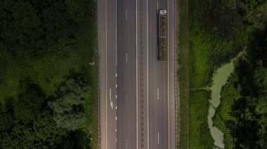 Karayolu trafiğinin yukarıdan aşağıya yakın kamyon, yönünü gösteren beyaz ok işaretleri