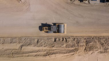 Silindirin yukarıdan aşağıya görünümü yolun inşaatı sırasında kum haddeleme.
