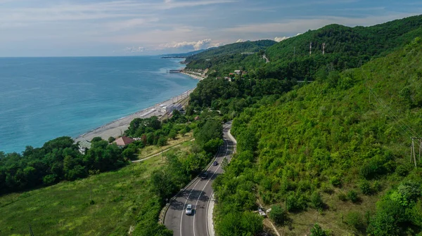 航空写真 - ソチ、ロシアへの山道の湾曲した道路。素晴らしいロードトリップは、密な森をトラフ. — ストック写真