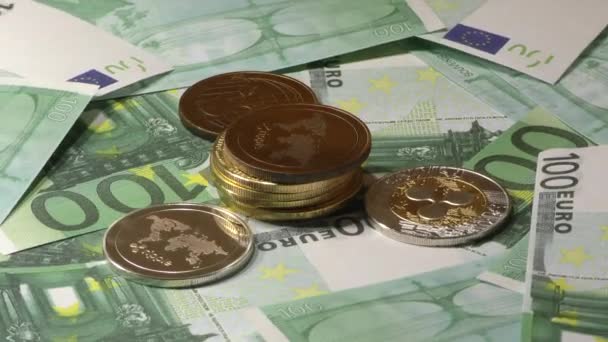 100ユーロ紙幣の紙幣に回転するリップルコイン。世界的な仮想インターネット暗号通貨. — ストック動画