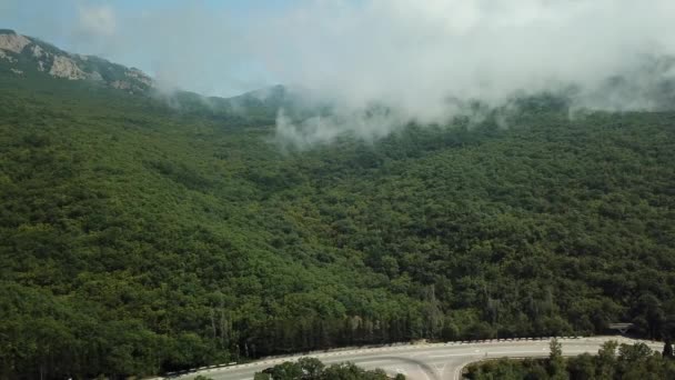 Crimeia com bela vista das montanhas e estrada entre as montanhas. Vista aérea de nuvens de rolamento rápido à deriva sobre montanhas e colinas . — Vídeo de Stock