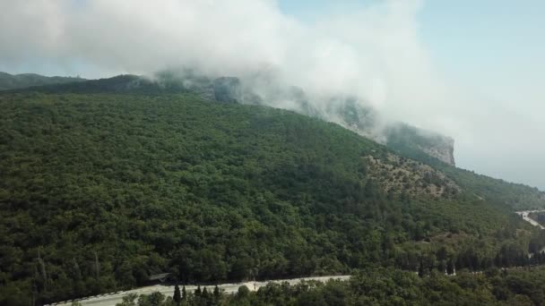 Crimea con bella vista delle montagne e strada statale tra le montagne. Veduta aerea di nuvole rotolanti veloci alla deriva su montagne e colline . — Video Stock