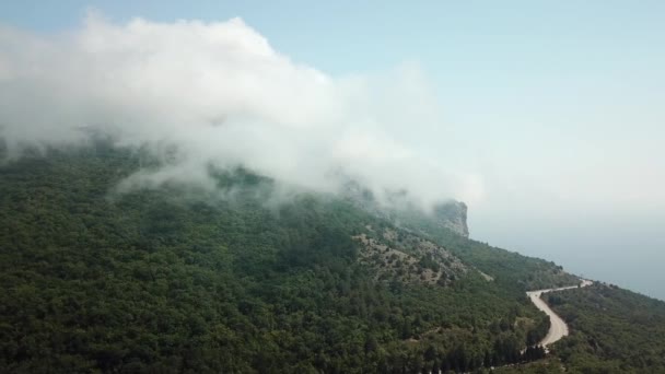 Crimea con hermosa vista de las montañas y carretera entre las montañas. Vista aérea de nubes de balanceo rápido a la deriva sobre montañas y colinas . — Vídeos de Stock