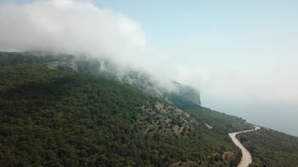 पर्वत आणि पर्वत दरम्यान महामार्ग रस्ता सुंदर दृश्य सह Crimea. डोंगर आणि टेकड्यांवर ड्रिपिंग फास्ट रोलिंग मेघ हवाई दृश्य . — स्टॉक व्हिडिओ