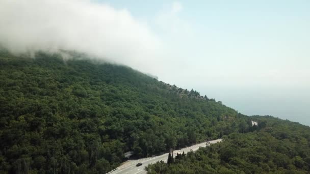 Krim met prachtig uitzicht op de bergen en de snelweg weg tussen de bergen. Luchtfoto van snel rollende wolken die over bergen en heuvels heen drijven. — Stockvideo