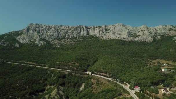 Crimea con hermosa vista de las montañas y carretera entre las montañas. Vista aérea de nubes de balanceo rápido a la deriva sobre montañas y colinas . — Vídeo de stock