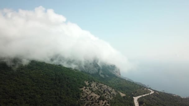 Krim met prachtig uitzicht op de bergen en de snelweg weg tussen de bergen. Luchtfoto van snel rollende wolken die over bergen en heuvels heen drijven. — Stockvideo