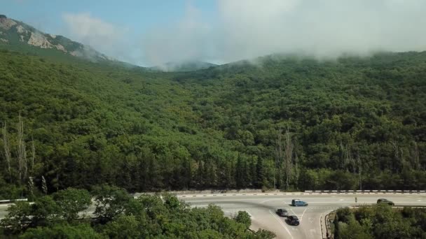 Crimea con hermosa vista de las montañas y carretera entre las montañas. Vista aérea de nubes de balanceo rápido a la deriva sobre montañas y colinas . — Vídeo de stock