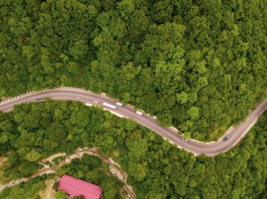 Dağ kıvrımlı zig zag yolu. Üst hava manzarası: Arabalar yukarıdan yola çıkıyor.