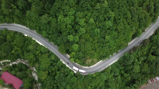 Gebirgsgewundene Zickzackstraße. Luftaufnahme von oben: Autos, die von oben auf die Straße fahren. — Stockvideo