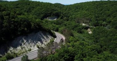 Dağ kıvrımlı zig zag yolu. Üst hava manzarası: Arabalar yukarıdan yola çıkıyor.