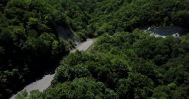 Dağ kıvrımlı zig zag yolu. Üst hava manzarası: Arabalar yukarıdan yola çıkıyor.