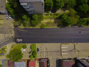 İnşaatın asfaltlanmasının havadan aşağı görüntüsü ticari tamir ekipmanları yol sıkıştırma makinesiyle çalışıyor. Yeni ve eski yol yüzeyi arasındaki karşıtlık.