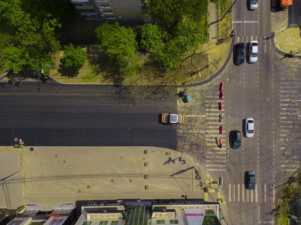 Vista aérea de arriba hacia abajo de las obras de construcción de asfalto con equipo de reparación comercial máquina compactadora de rodillos de carretera. Contraste entre la superficie de la carretera nueva y antigua . — Foto de Stock