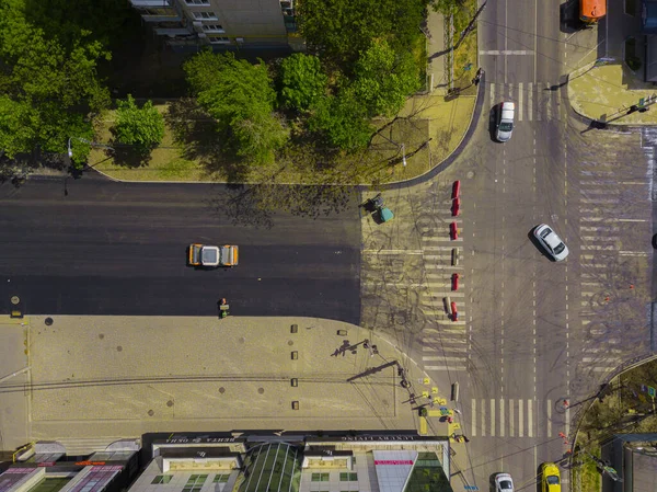 Vista aérea de arriba hacia abajo de las obras de construcción de asfalto con equipo de reparación comercial máquina compactadora de rodillos de carretera. Contraste entre la superficie de la carretera nueva y antigua . — Foto de Stock