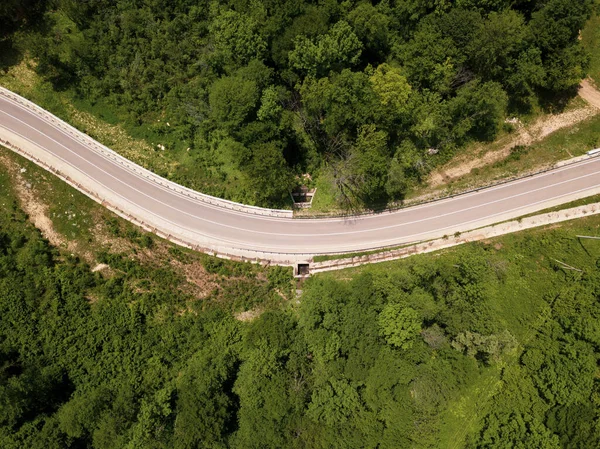 Повітряний вид звивистої дороги в кавказьких лісах. Літній сезон. — стокове фото