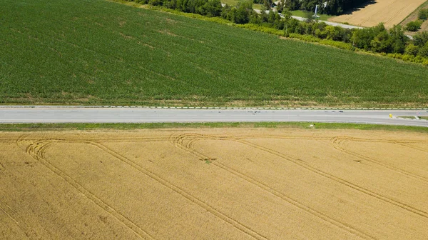 Vista aérea de carretera vacía carretera entre prado y campo agrícola . — Foto de Stock