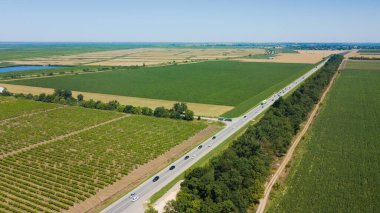 Çayır ve tarım arazisi arasındaki boş otoyol manzarası.