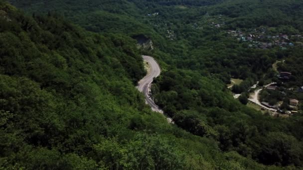 Virajlı yolun yukarısından Rusya 'da yeşil ormanlı dağda bir arabayla hava manzarası. — Stok video