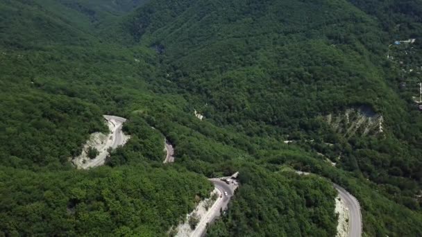 Vista aérea de cima da estrada de curva com um carro na montanha com floresta verde na Rússia — Vídeo de Stock