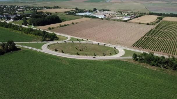 Vue aérienne du cercle routier routier vide entre prairie et champ agricole.