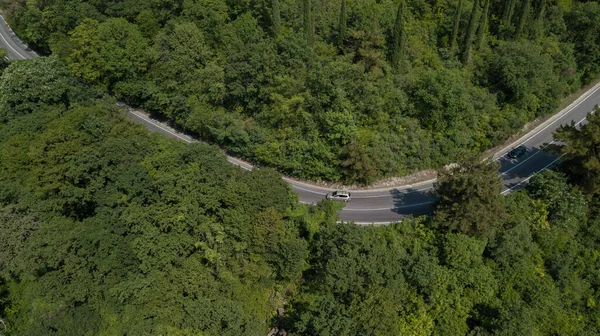 Вид з літака з кривої дороги з автомобілем на горі з зеленим лісом в Росії. — стокове фото