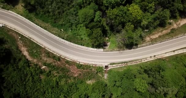 Flygfoto från drönare av kurva väg med en bil på berget med grön skog i Ryssland — Stockvideo