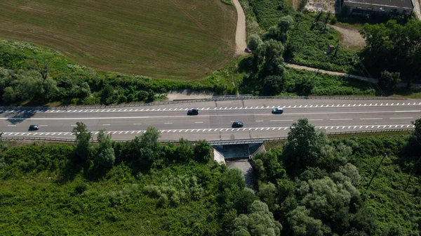 ロシアの緑の森を持つ車とカーブ高速道路の道路の上からの空中ビュー — ストック写真