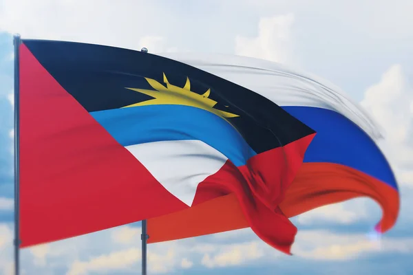 Acenando bandeira russa e bandeira de Antígua e Barbuda. Vista de perto, ilustração 3D. — Fotografia de Stock