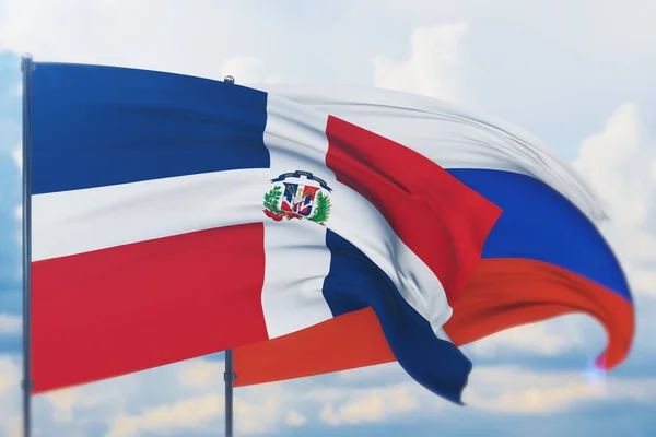 Das Schwenken der russischen Flagge und der Flagge der Dominikanischen Republik. Nahaufnahme, 3D-Illustration. — Stockfoto