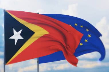 Avrupa Birliği bayrağı ve Doğu Timor bayrağı sallıyordu. Yakın görünüm, 3 boyutlu illüstrasyon.